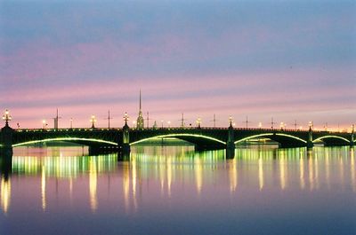 Bridge in city against sky during sunset