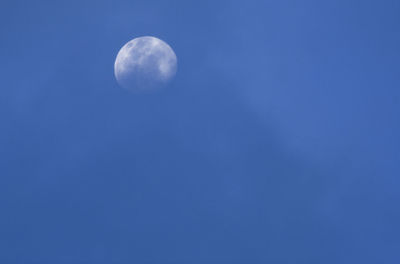 Low angle view of moon against blue sky at night