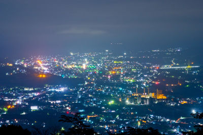 Illuminated cityscape against sky at night