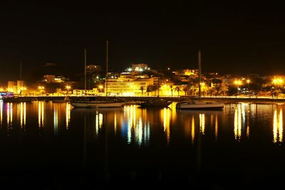 Illuminated bridge over river at night