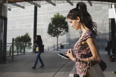 Young woman looking at cell phone in the city