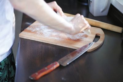 Midsection of person preparing food on cutting board