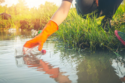 Low section of woman cleaning lake