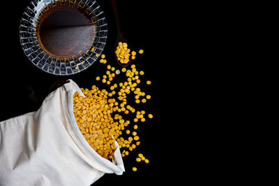 Close-up of yellow bowl over black background