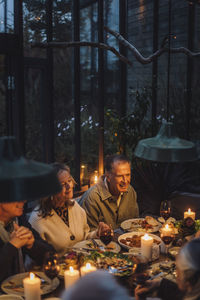 Happy senior male and female friends having food at dinner party