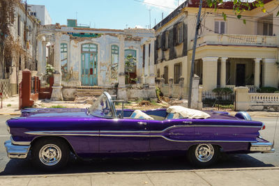 Vintage car on street against buildings in city