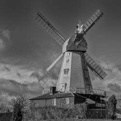 A low angle view of traditional kentish smock windmill against sky in black and white. 