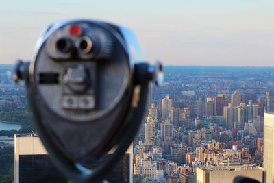 Coin-operated binoculars against cityscape