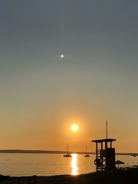 Silhouette sailboat in sea against sky during sunset