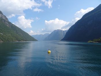 Buoy in sea against mountains