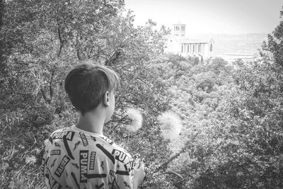 Rear view of boy standing by tree