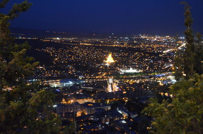 High angle view of illuminated cityscape against sky at night