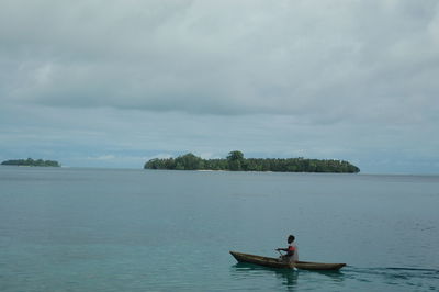 Man in boat on sea against sky