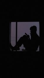 Side view of silhouette man using mobile phone