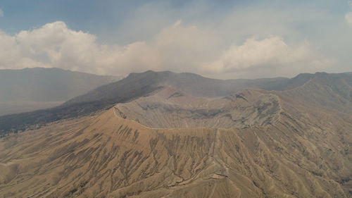 Active volcano bromo with smoking crater. volcano crater and mountains tengger semeru national park.