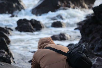 Rear view of man sitting on land during winter