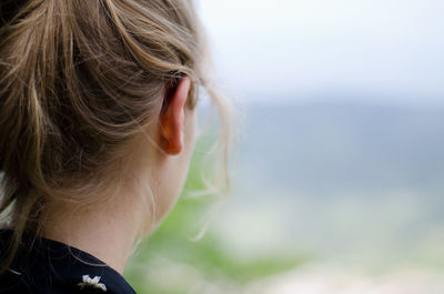 Rear view of woman with blond draped hair looking away