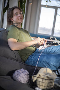 Portrait of young woman sitting on sofa at home