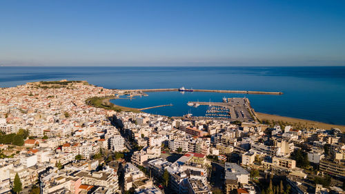 High angle view of city by sea against clear sky