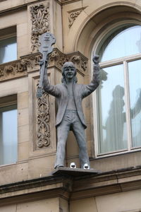 Low angle view of statue against historic building