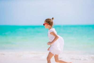 Woman standing on beach against sky