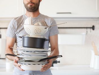 Mid section of man holding camera at home