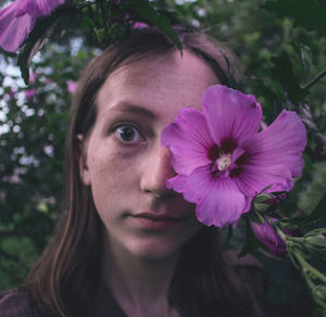 Close-up of young woman holding flower