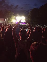 Crowd at music concert against sky at night