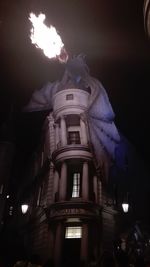 Low angle view of illuminated statue against sky at night