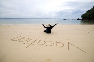 Text on beach against sky