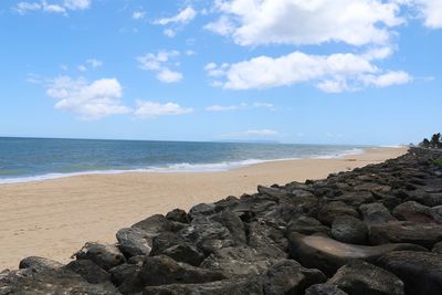 Rocks on beach against sky