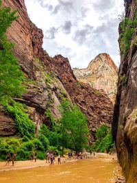 Group of people by river amidst rock formations