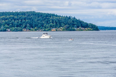 Boats sailing in sea against sky