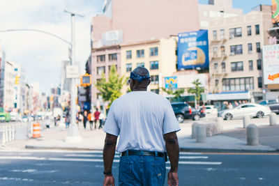 Rear view of man standing on city street