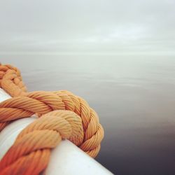 Rope on boat at sea against sky