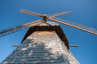 Low angle view of traditional windmill against blue sky