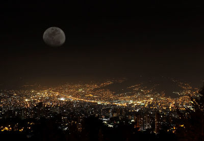 Aerial view of illuminated cityscape against sky at night