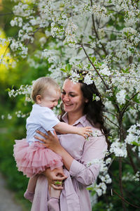 Portrait of smiling young woman holding flowers