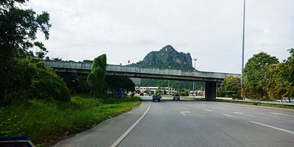 Road by bridge against sky