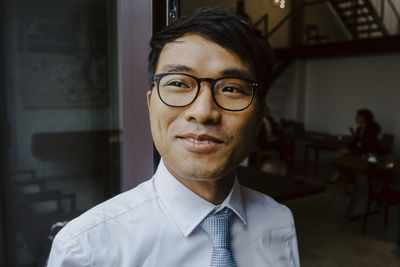 Happy male entrepreneur looking away in office