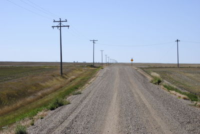Road amidst field against sky