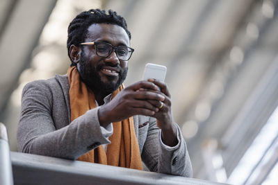 Low angle view of businessman using phone at airport