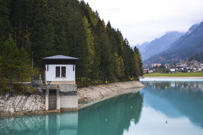 Scenic view of lake by trees and mountains against sky