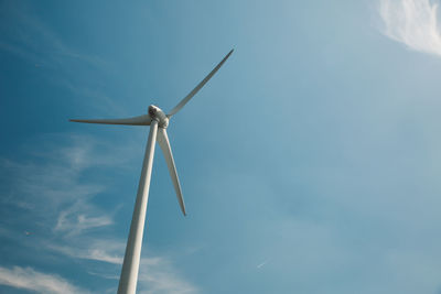 Low angle view of windmill against blue sky