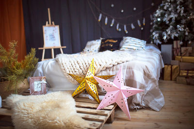 Christmas interior decor in loft style. a bed on a pallet, a large-knitted plaid,
