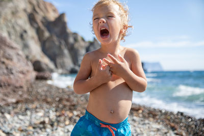 Portrait of young woman standing at beach