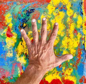 Close-up of man hand over colorful table
