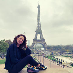 Woman sitting against tower in city