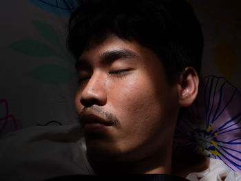 Close-up of young man sleeping on bed at home