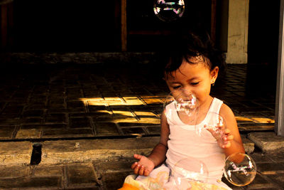 Smiling girl playing with bubble